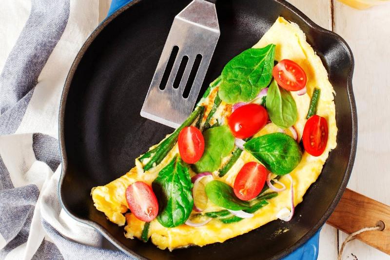 Omelette with green bean. spinach and tomato in a skillet. top view Omelette with green bean. spinach and tomato in a skillet. top view