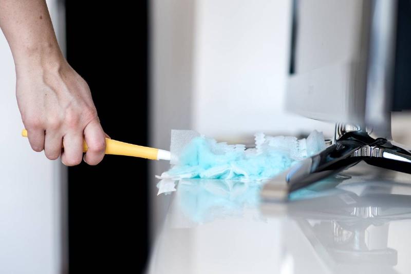 GettyImages-1132452989 person using duster person using duster to clean white cabinet