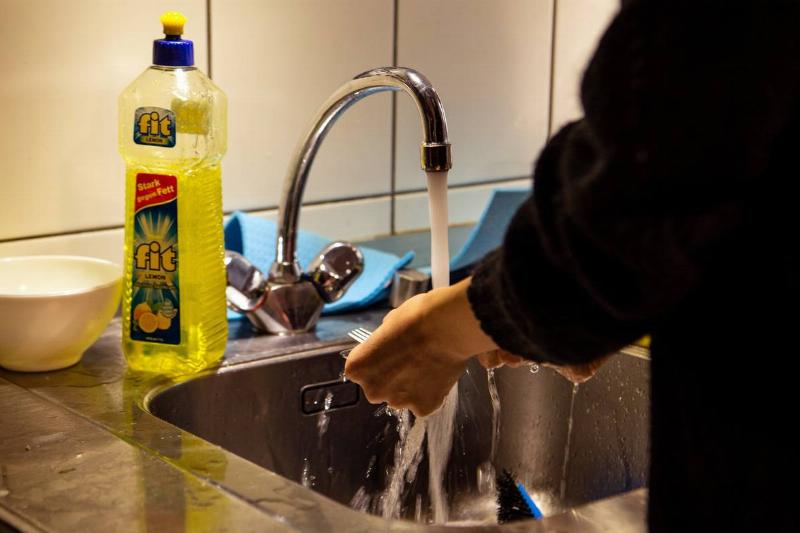 GettyImages-1229809822 person doing dishes by hand at sink one person washing dishes by hand in sink in berlin