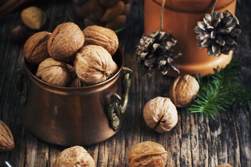 Walnuts Whole and cracked walnuts sit in a bowl.