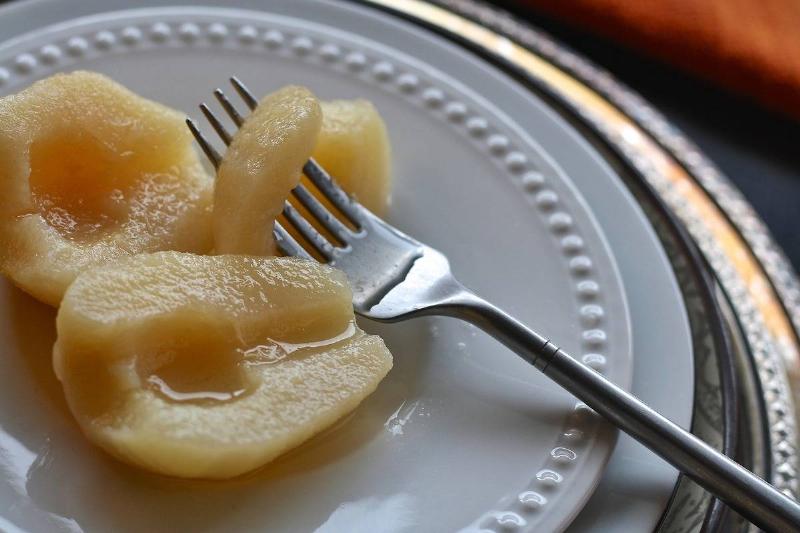 canned pears Canned pears sit on a plate with a fork.