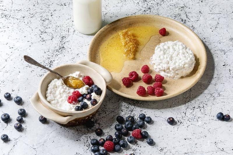 cottage cheese Two ceramic bowls of cottage cheese also feature honey and berries.