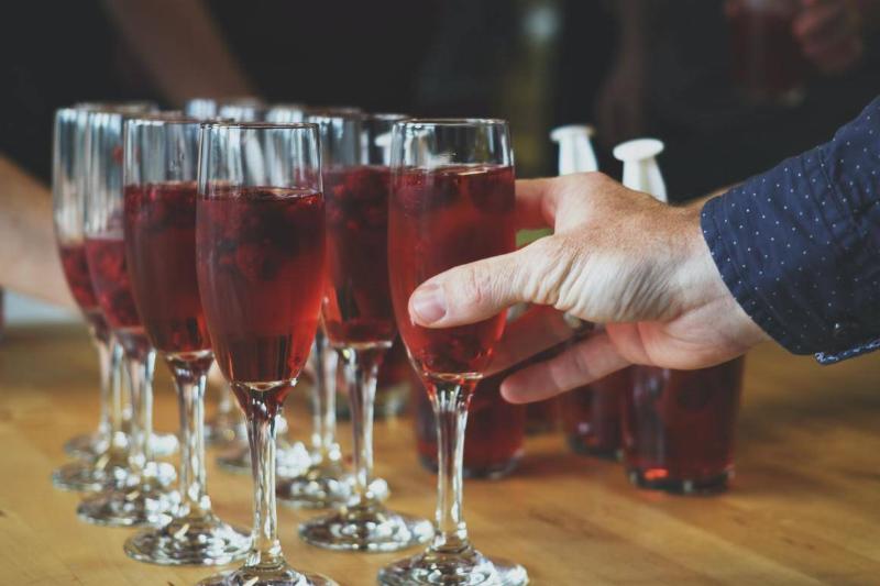 cranberry juice A person picks up a glass of cranberry juice from a serving tray.