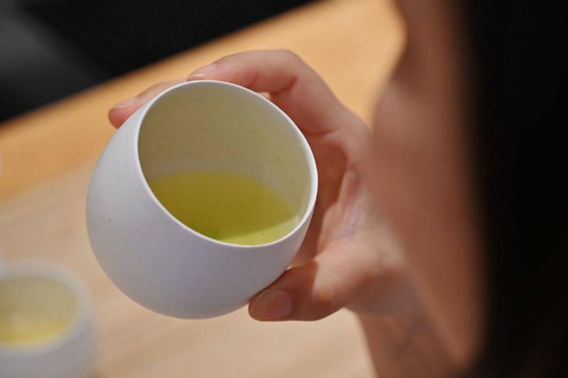 green tea A woman drinks a cup of Japanese green tea.