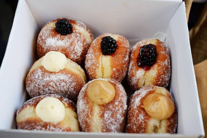 jelly filled donuts Jelly-filled donuts in a box are topped with berries and cream.