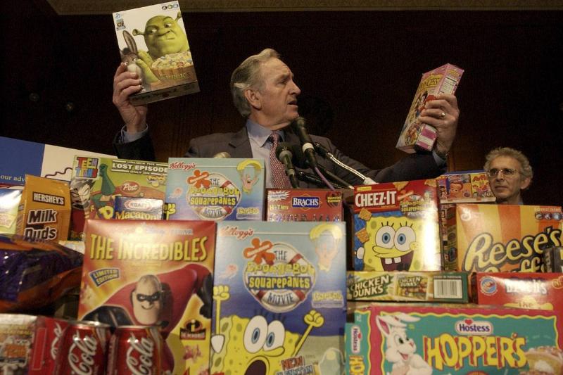 sugary cereals-99618659 A man looks at sugary kid's cereals in disbelief.