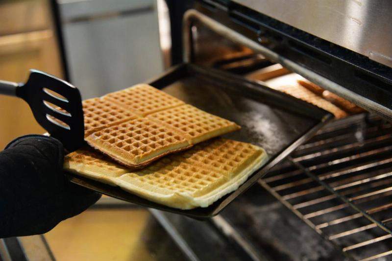 waffles A chef takes Belgian waffles out of an oven.
