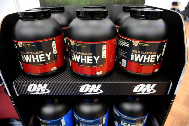 whey protein-676945066 Tubs of whey protein for shakes are for sale on a store shelf.