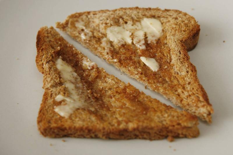 whole grain toast Two slices of whole grain toast have butter.