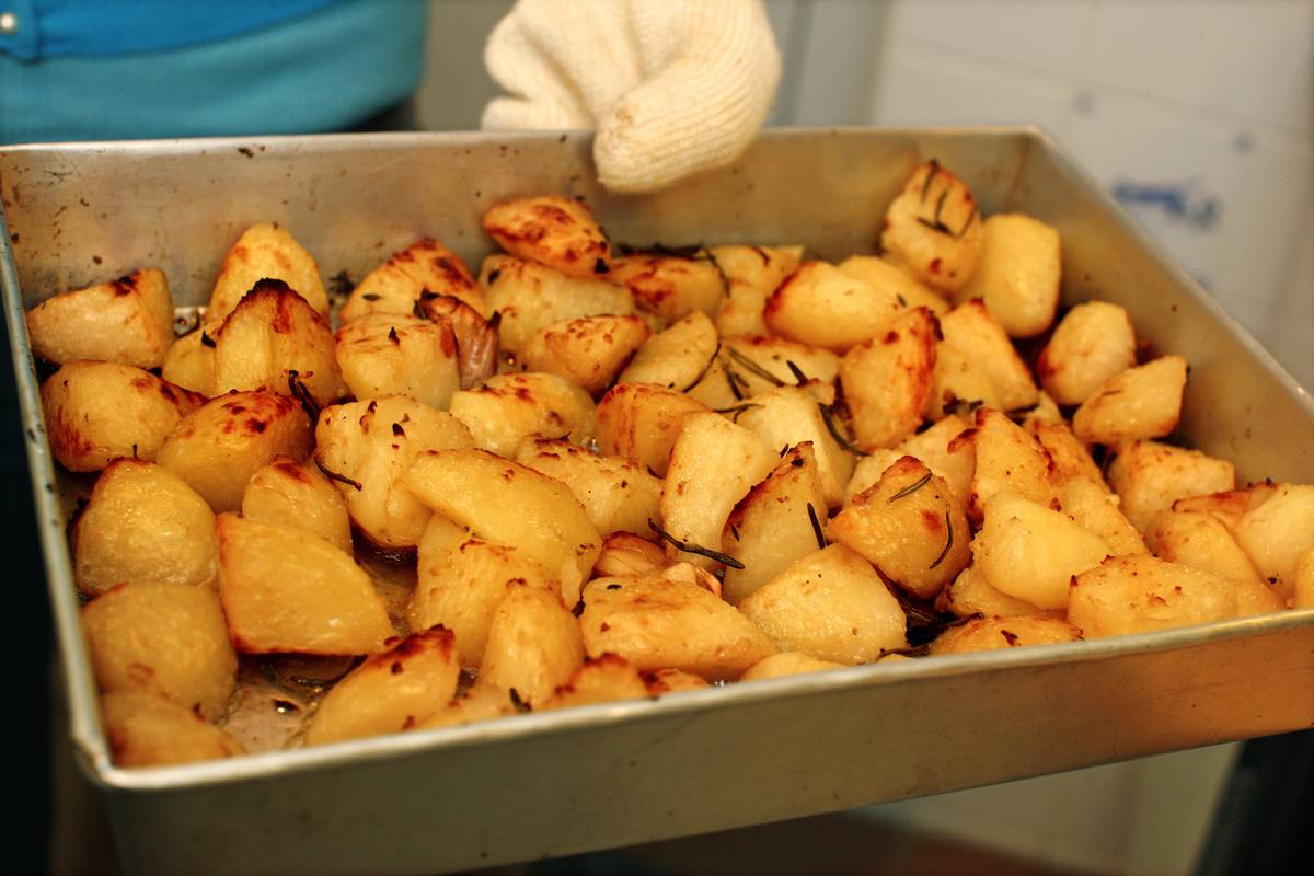 pan of potatoes A chef holds a pan of roasted potatoes.