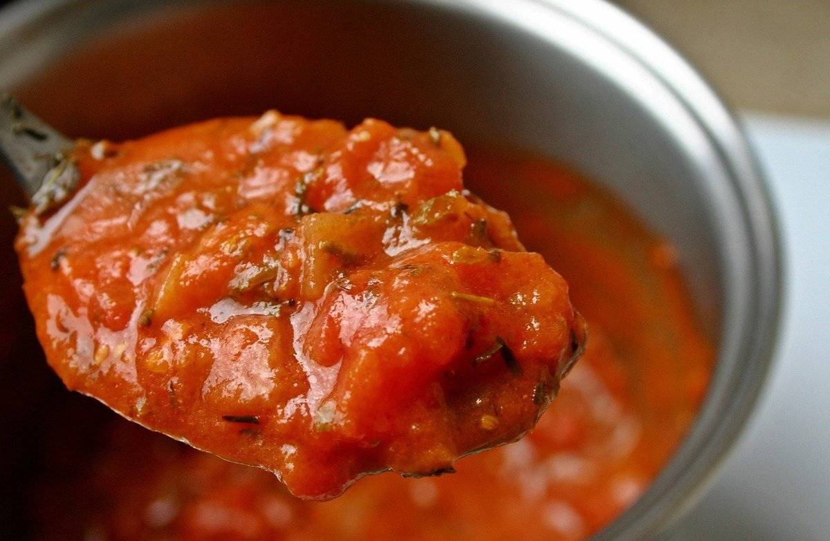 tomato soup A spoon scoops up some tomato sauce.