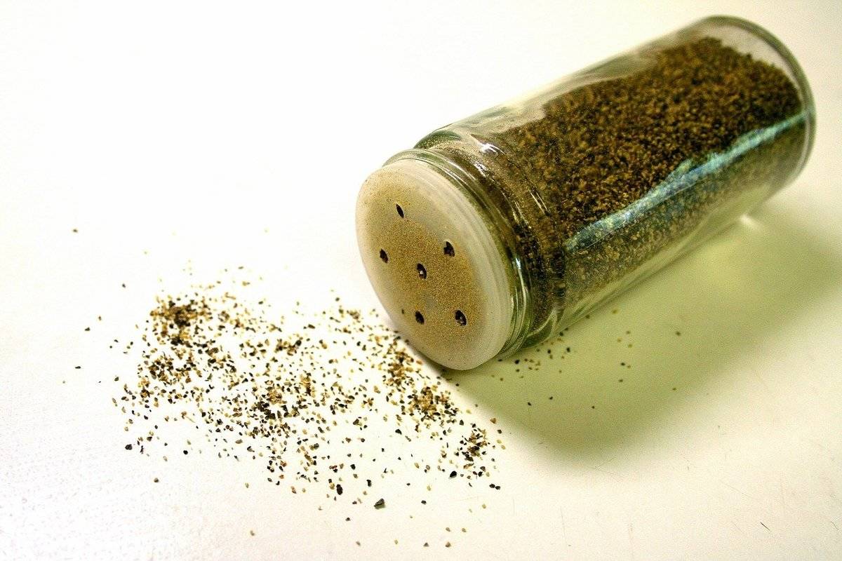 A black pepper shaker is tipped over.