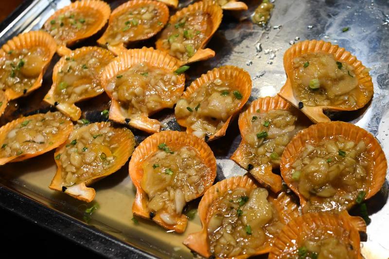 Mini scallops are on a tray and displayed for sale.