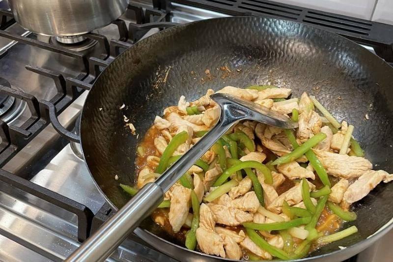 meal-being-cooked-using-a-wok.-cooking-using-a-wok-over-gas-stove-a-chinese-meal-of-chicken-and-scallions-new-york-city-98853