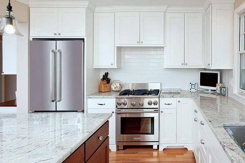 A kitchen from the 2010s has white cabinets and quartz marble countertops.