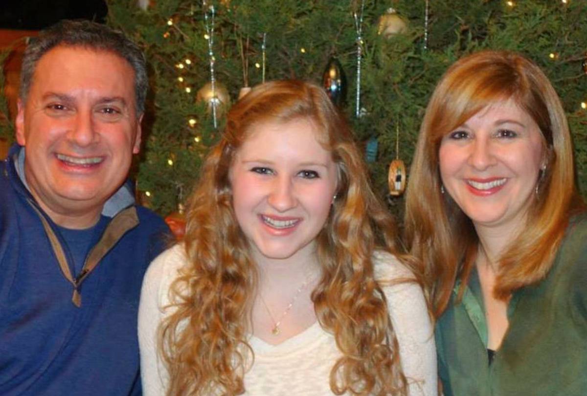 Rebecca and her parents, Joe and Jennifer, are in front of their Christmas tree.