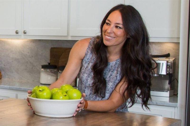 Joanna-Gaines-pushing-a-bowl-of-apples-on-the-kitchen-counter-84524