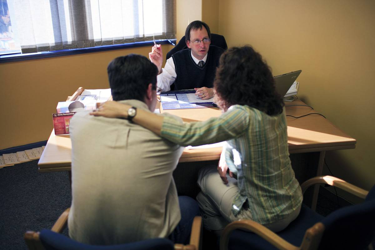 A couple talks to a professional at a fertility clinic.