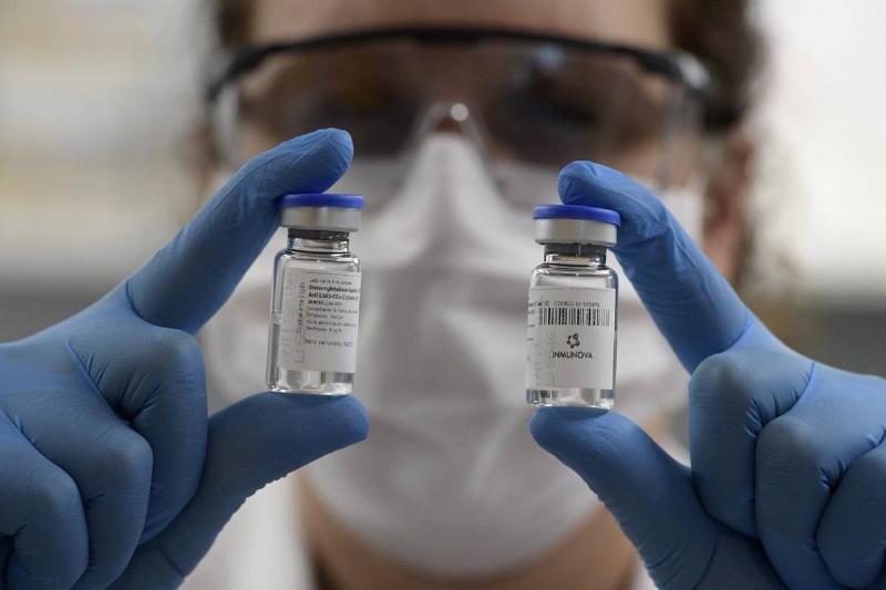 A woman holds up vials of embryos for IVF treatments.