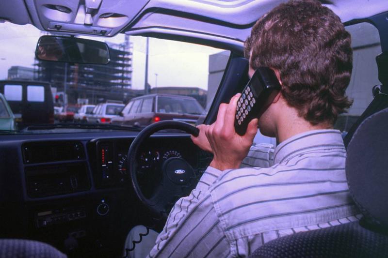 Man Driving Whilst Using Built-In Car Telephone 1990. Creator: Unknown. Man Driving Whilst Using Built-In Car Telephone 1990. Creator: Unknown.