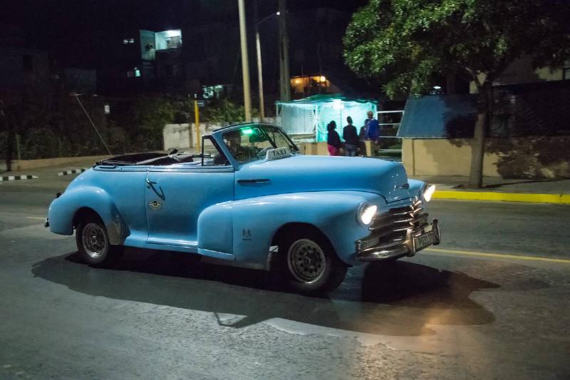 Old vintage American blue car in action at night. The... Old vintage American blue car in action at night. The...