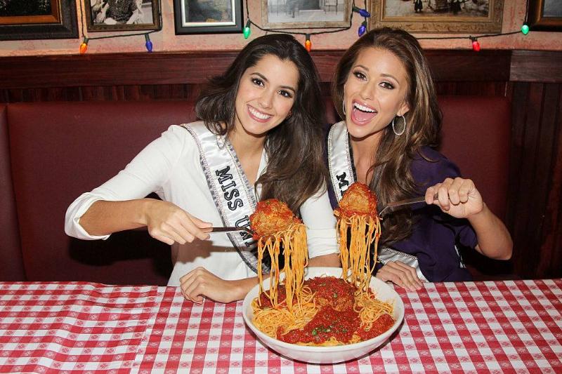 portion 462846906 two young women eating a big bowl of spaghetti and meatballs
