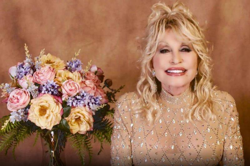 blonde 1313347794 Dolly Parton sitting next to a bouquet of flowers