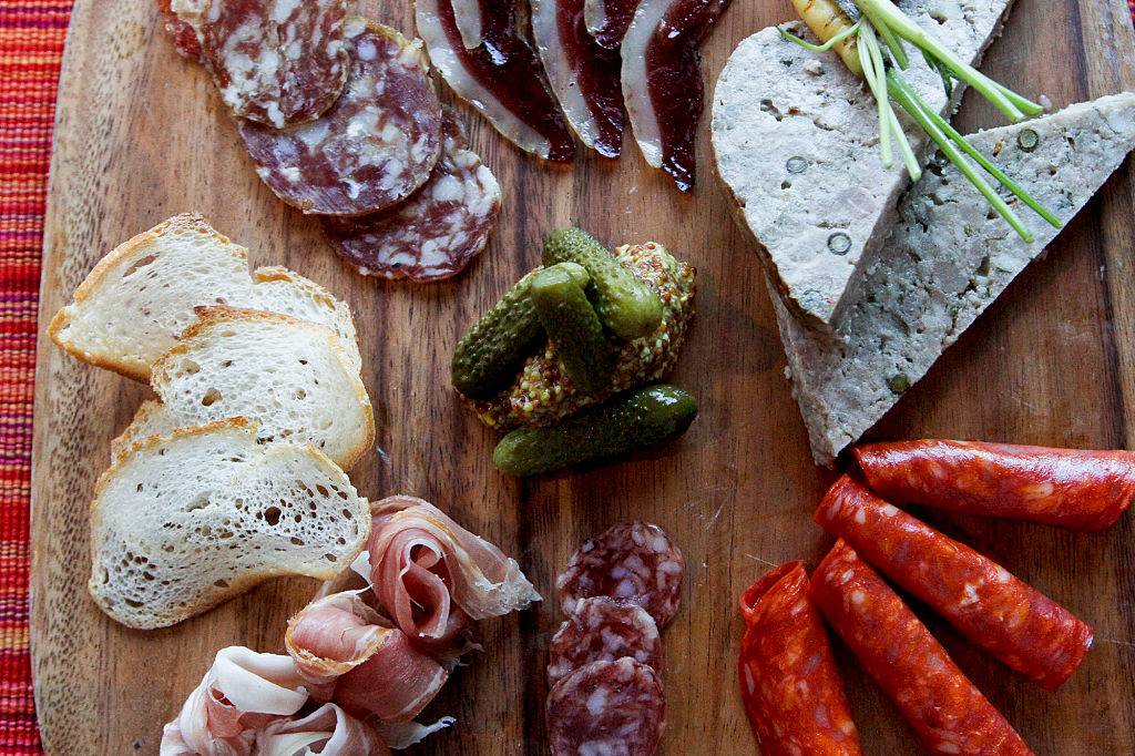 Tapas charcuterie board with pickles, cheese, bread, and meat