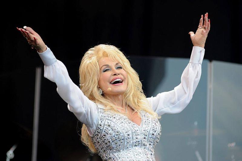 nails 451441220 Dolly Parton on stage with her arms raised