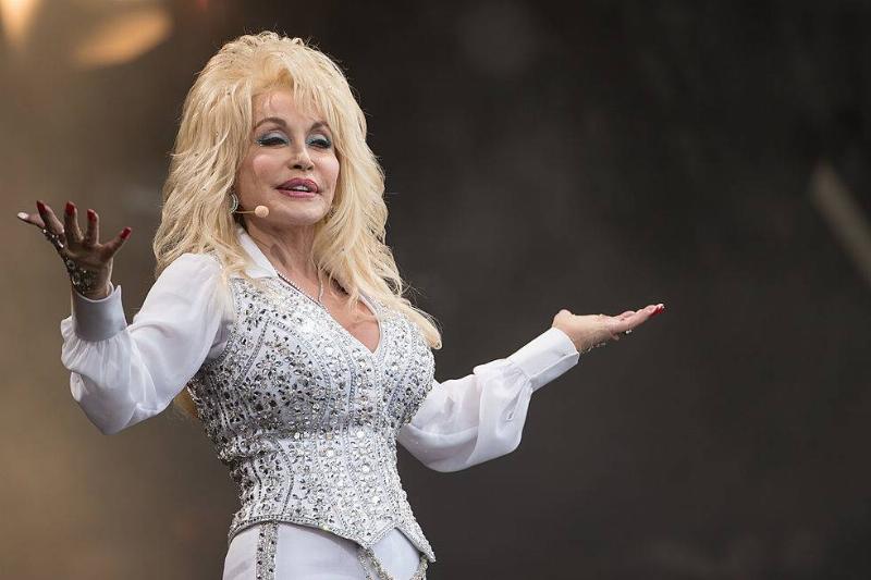 natural hair 451440796 Dolly Parton on stage in a white outfit