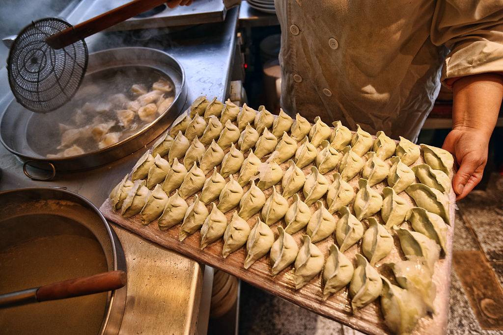 A chef prepares dumplings in a restaurant in China Town