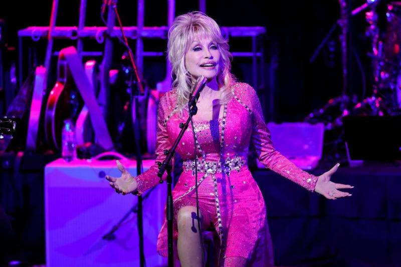 work done 1348821252 Dolly Parton performing on stage in a pink dress