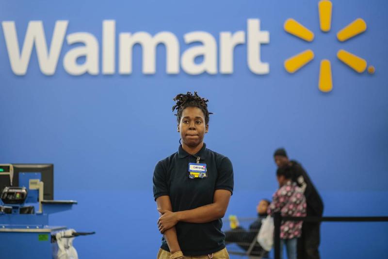 Checkout Christina Ford, stands by to help customers at the self checkout registers at a new Wal-Mart in Washington, DC