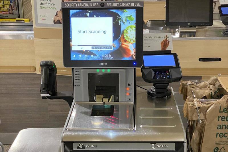 self checkout self checkout machine with a sticker saying a camera is watching