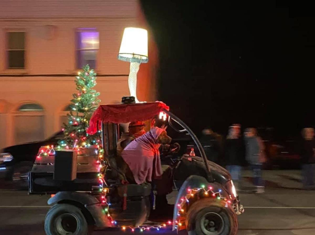 small car driving down the street with Christmas tree, lights, leg lamp from A Christmas Story and dog wearing pink bunny suit