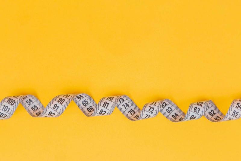 measuring tape across yellow background