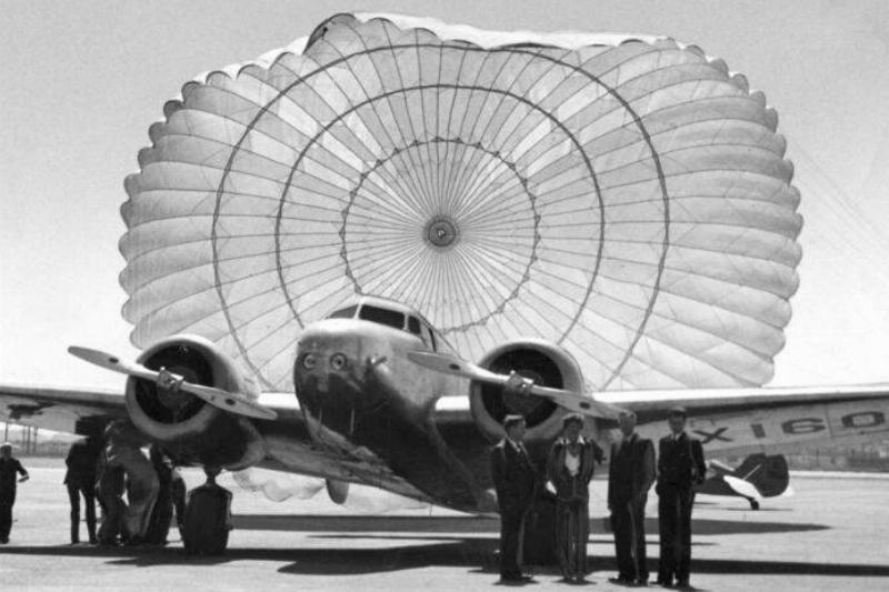 Amelia Earhart and plane at San Francisco Bay Airdrome with plane parachute billowing behind Amelia Earhart and plane at San Francisco Bay Airdrome with plane parachute billowing behind