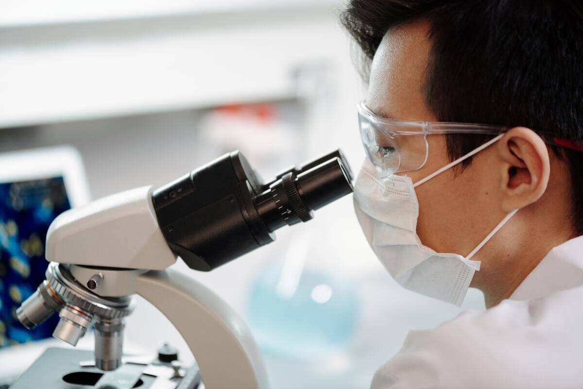 A scientist looking into a microscope.
