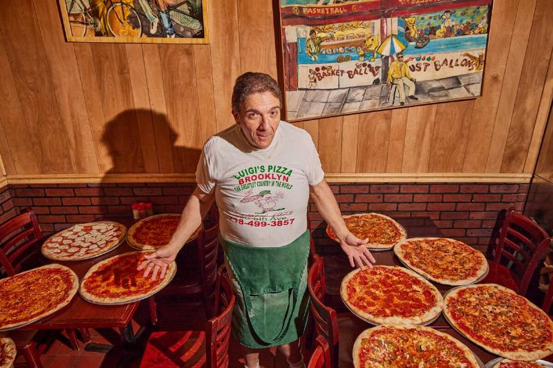 Owner Giovanni Luigi and all his pizza at Luigi's Pizza in Broo Owner Giovanni Luigi and all his pizza at Luigi's Pizza in Broo