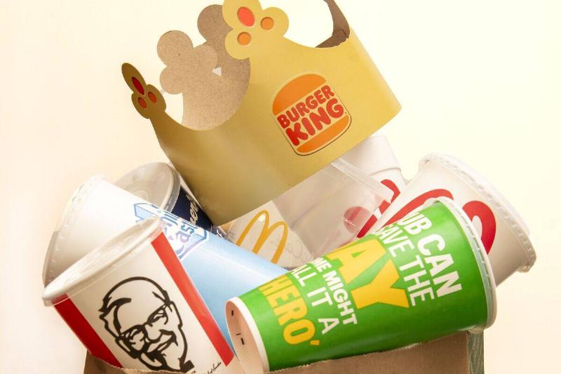 A trash bag full of fast food drink containers from a variety of fast food restaurants A trash bag full of fast food drink containers from a variety of fast food restaurants