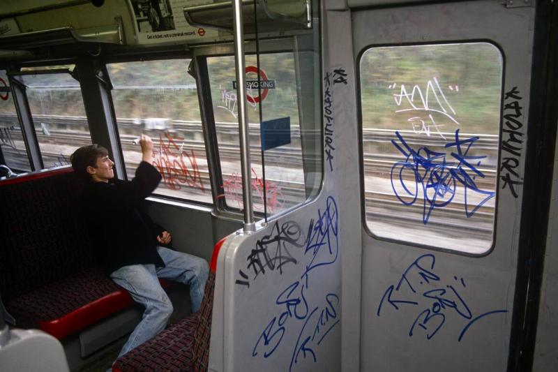England - London - Young graffiti tagger on underground train England - London - Young graffiti tagger on underground train