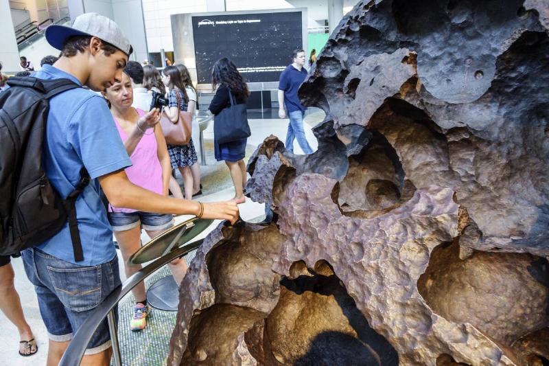 New York City, Hayden Planetarium, Students touching Willamette meteorite