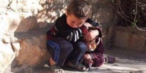 Heartbreaking photo of syrian boy protecting his little sister from air strike.