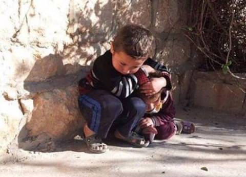 Heartbreaking photo of syrian boy protecting his little sister from air strike.