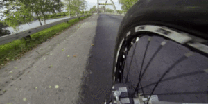 POV Footage of a Guy Riding His Bike over a Bridge’s Arch Beam