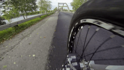 POV Footage of a Guy Riding His Bike over a Bridge's Arch Beam