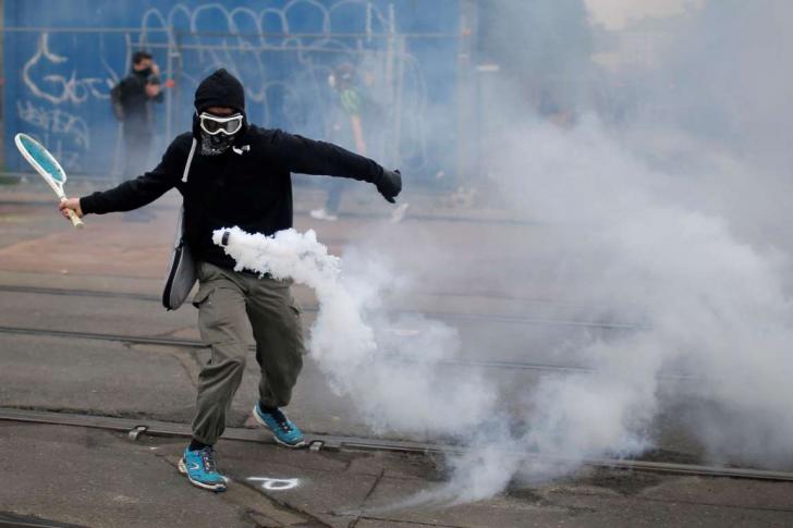 Protester hitting a tear gas canister back at the police