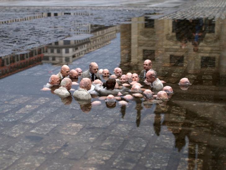 Sculpture by street artist Isaac Cordal, titled "Politicians Debating Global Warming"