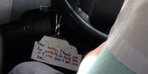 A note hanging from this taxi driver's steering wheel