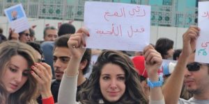 Tunisian Protester holding A Sign That Says Grow The Brain Before The Beard